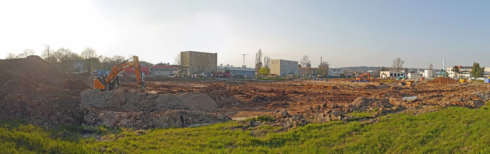 Excavators clearing ground at a data centre construction site on Borsigallee and Gwinnerstrasse in Frankfurt-Seckbach, Germany, with industrial buildings behind